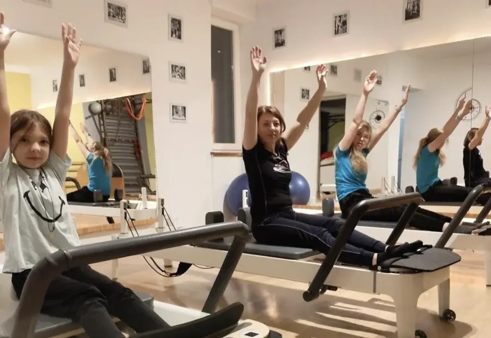 Clasă de grup la reformer cu mai multe participante în studio